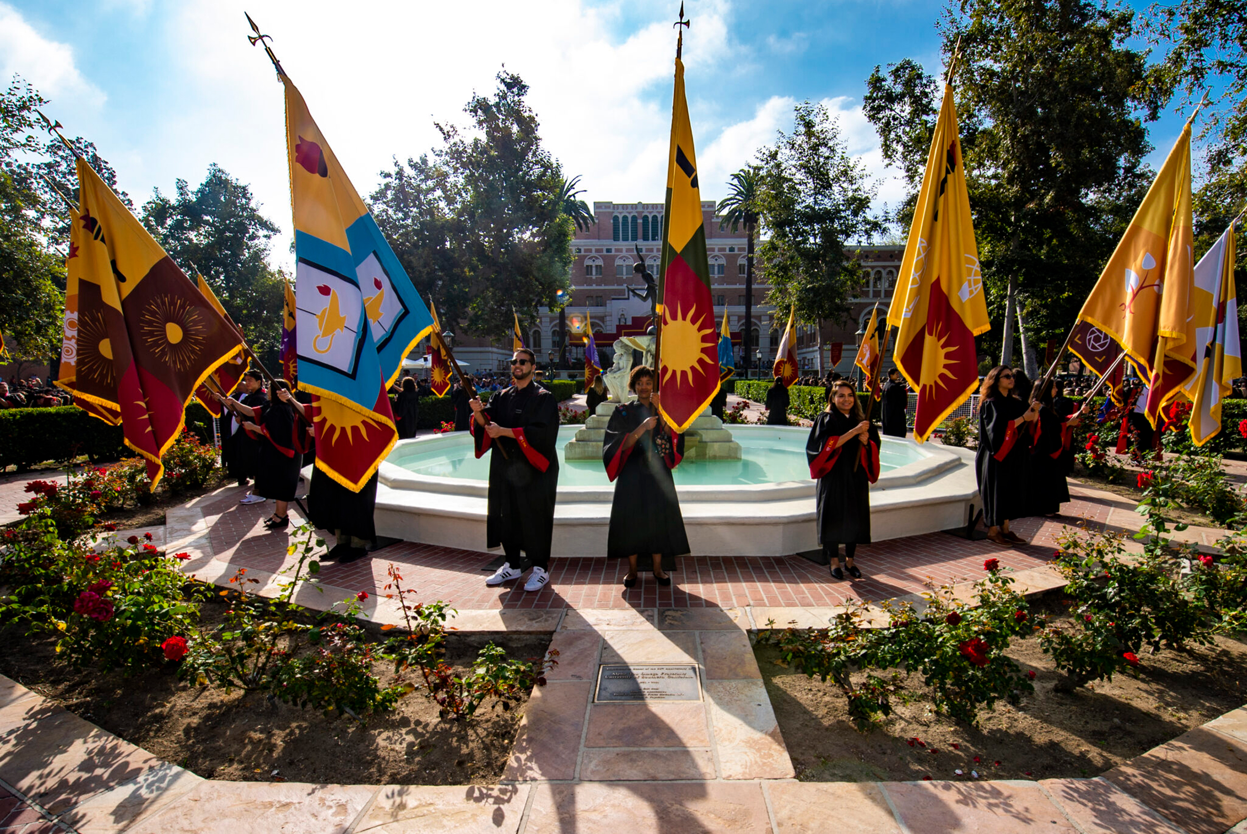 Flag bearers march into Alumni Park during new student Convocation